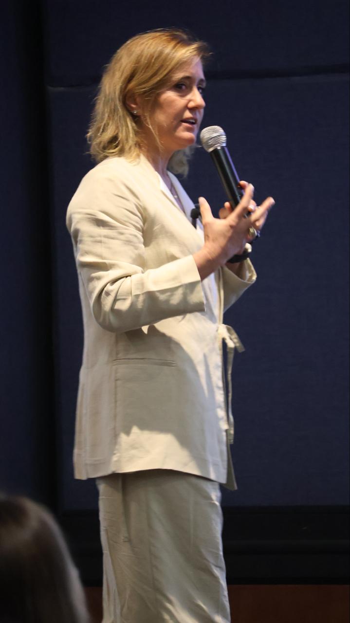 Marie Louise Clark hablando con el micrófono en un congreso
