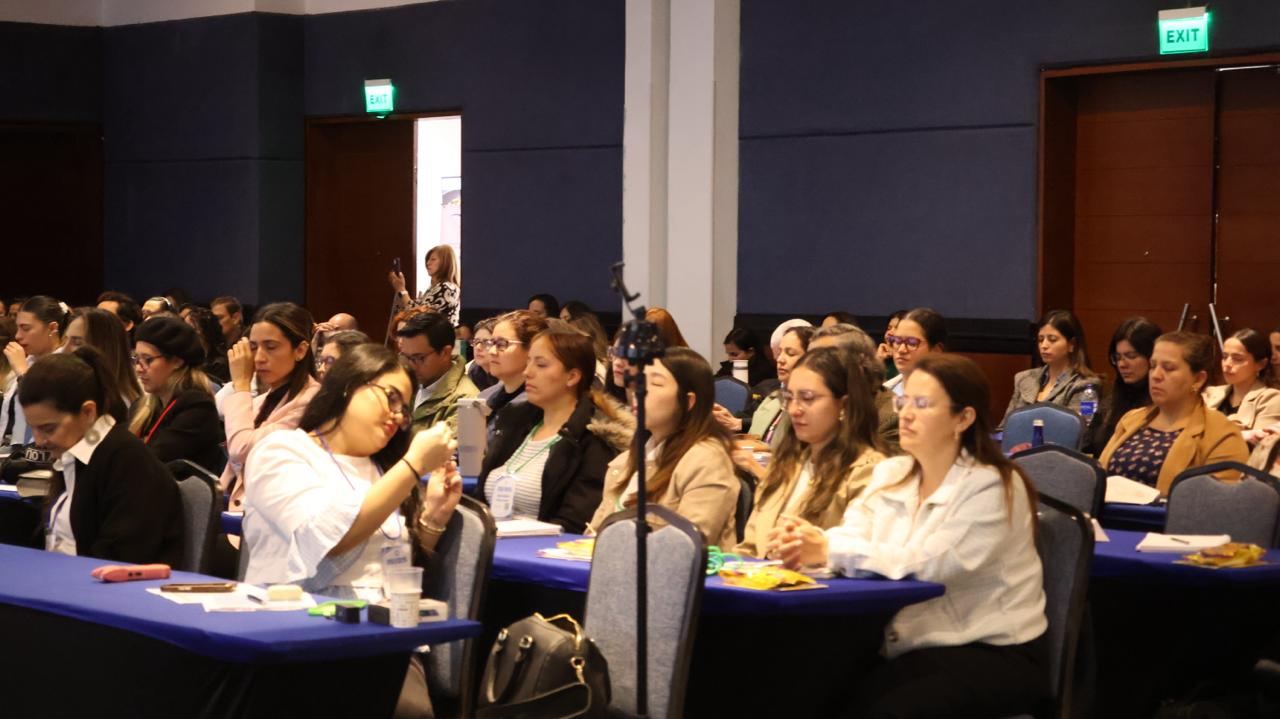 Sala llena de profesionales y familias en un congreso de Marie Louise Clark